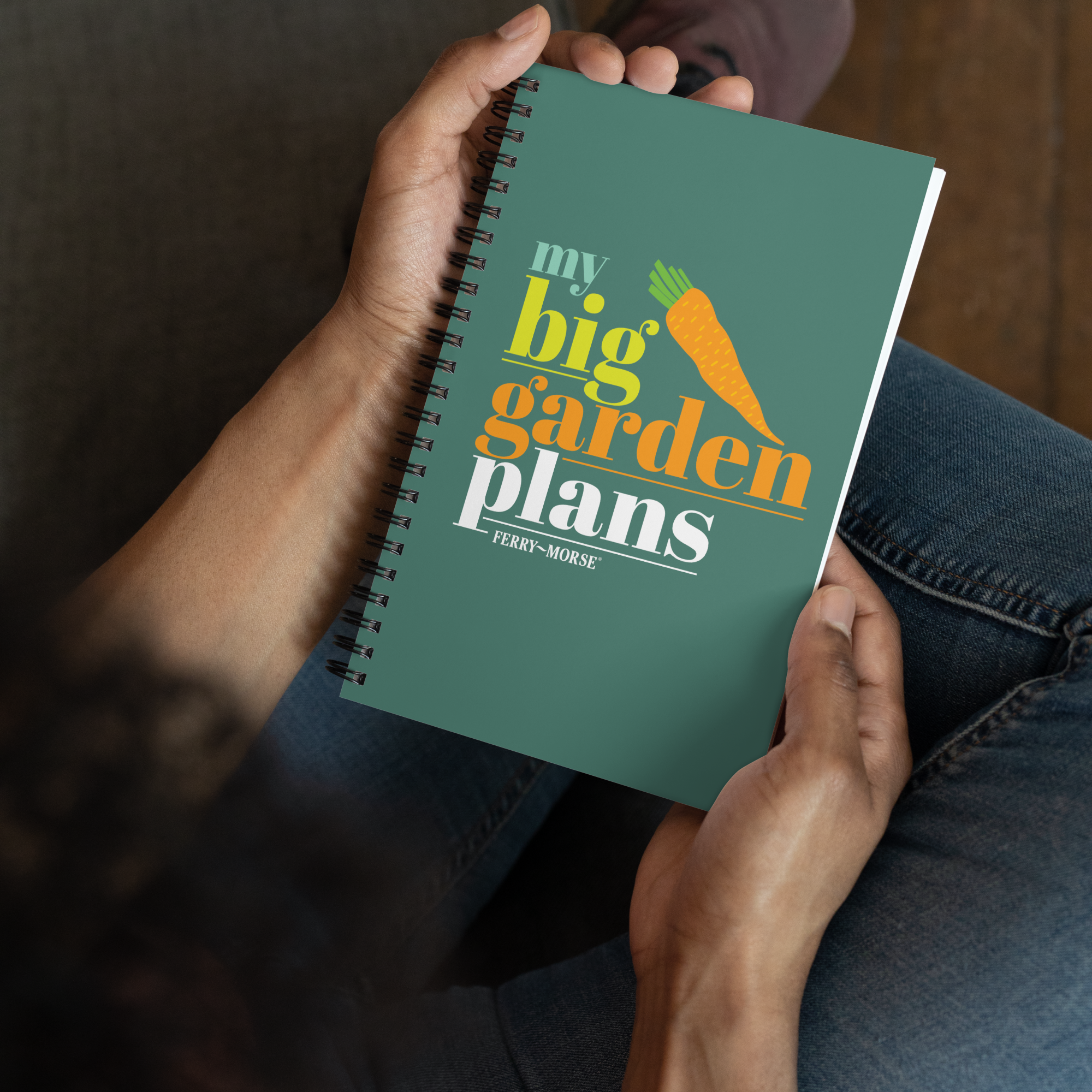 A green spiral-bound notebook with the title 'my big garden plans' printed on the cover, alongside an illustration of a carrot.